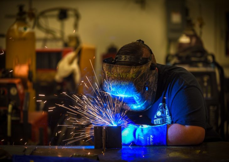Person welding in blue light