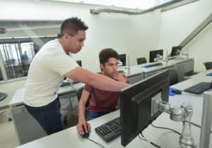 Instructor teaching student on computer